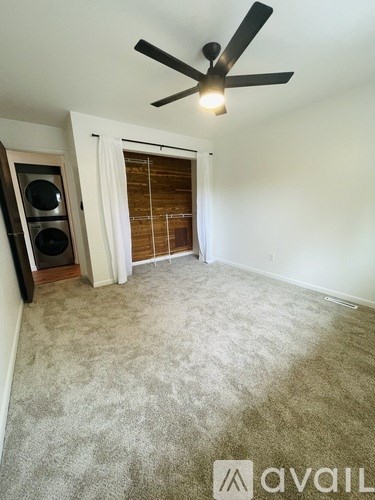A room with a ceiling fan and a carpeted floor.
