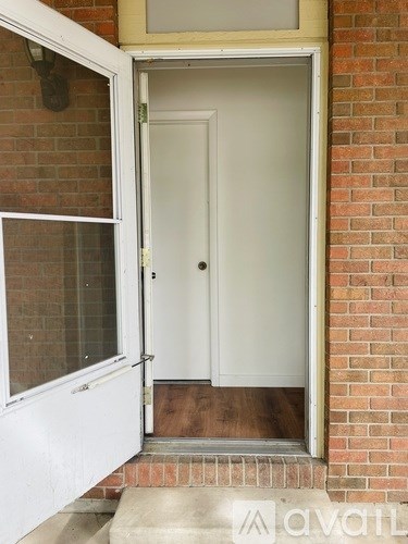A white door is open to a hallway.