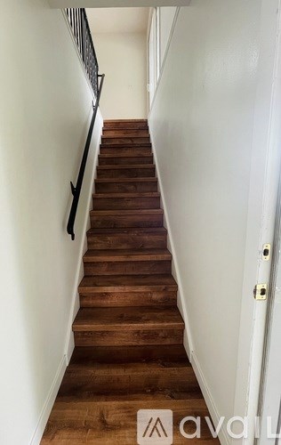 A staircase with wooden steps and a metal railing.