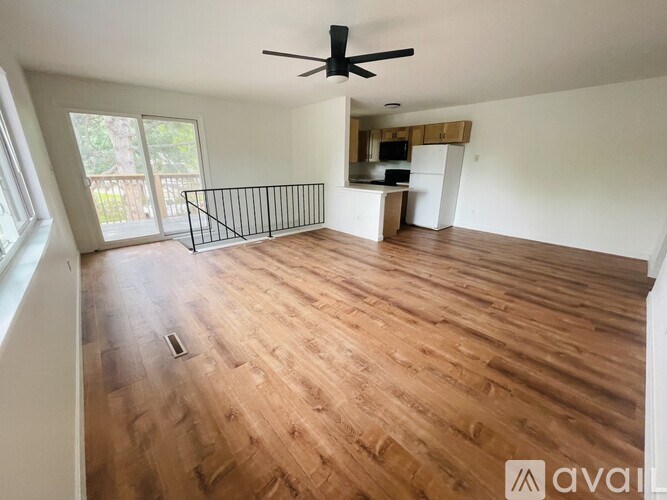 A room with wooden flooring and a ceiling fan.