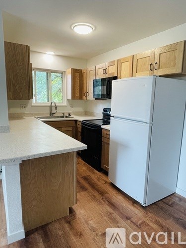 A kitchen with a white fridge and wooden cabinets.