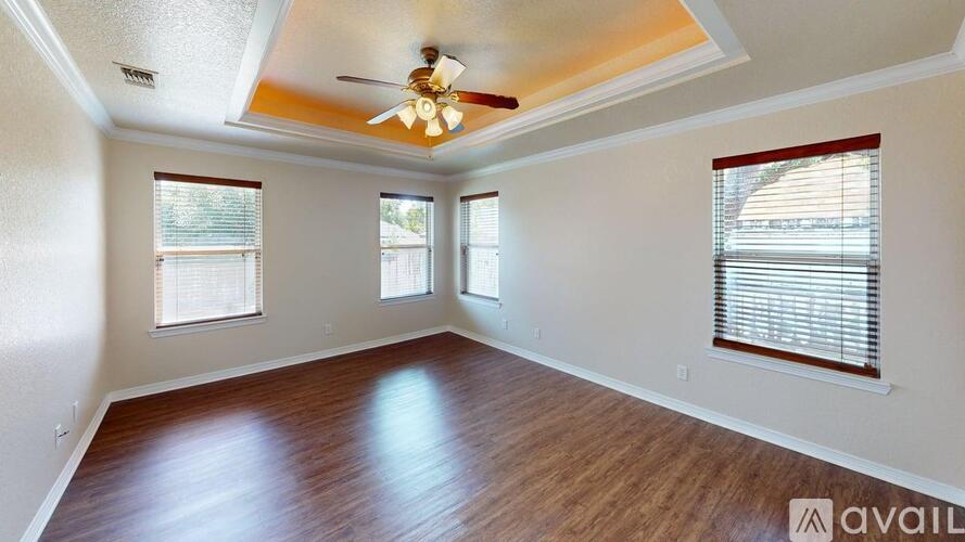 A room with wooden floors and a ceiling fan.