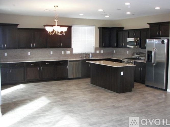 A kitchen with dark wood cabinets and a center island.
