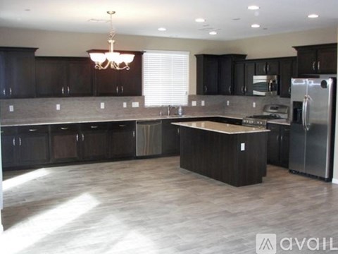 A kitchen with dark wood cabinets and a center island.