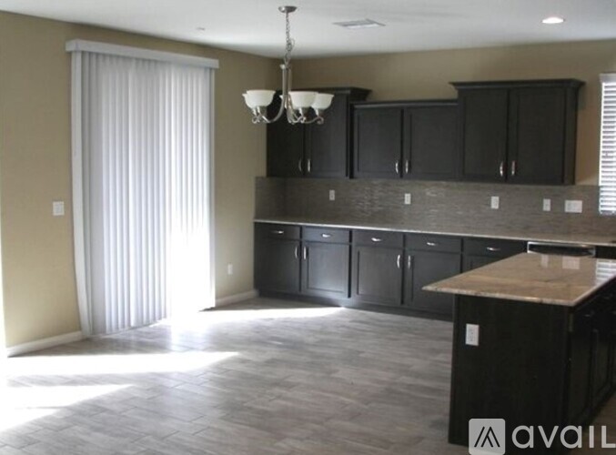 A kitchen with black cabinets and a wooden island.