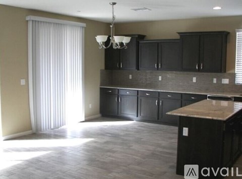 A kitchen with black cabinets and a wooden island.