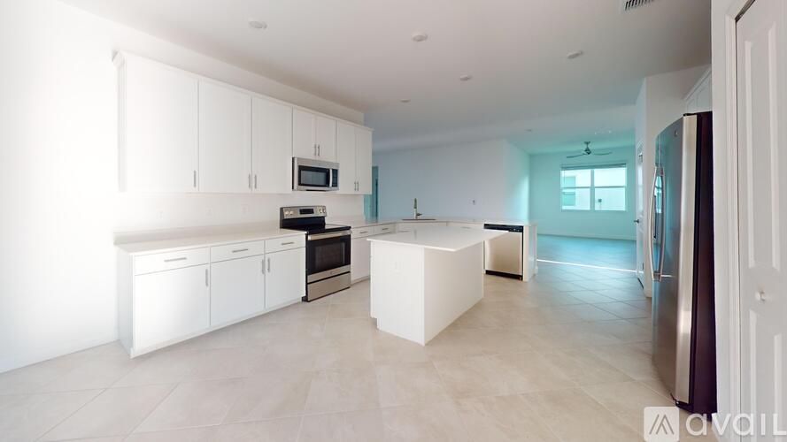 A modern kitchen with white cabinets and appliances.