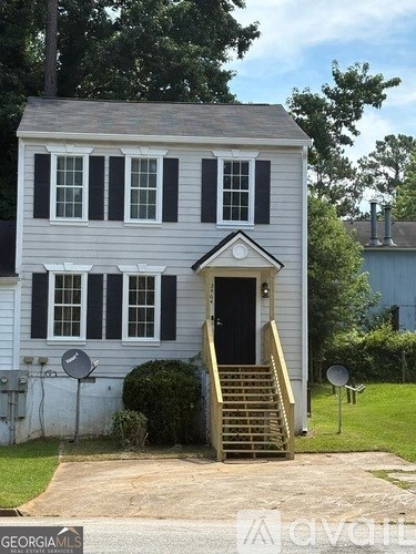 A white house with black shutters and a black door.