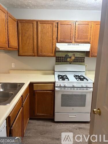 A kitchen with wooden cabinets and a white stove top oven.