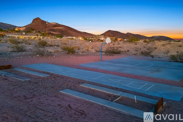 A basketball court in the desert with a mountain in the background.
