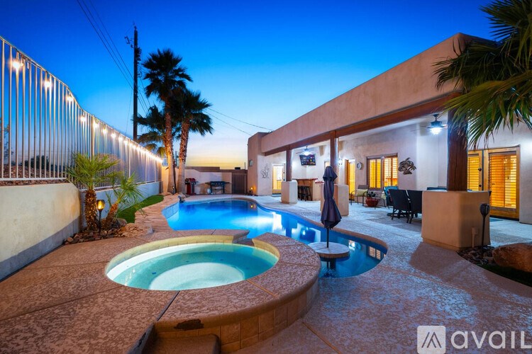 A pool with a hot tub in the middle of a backyard.
