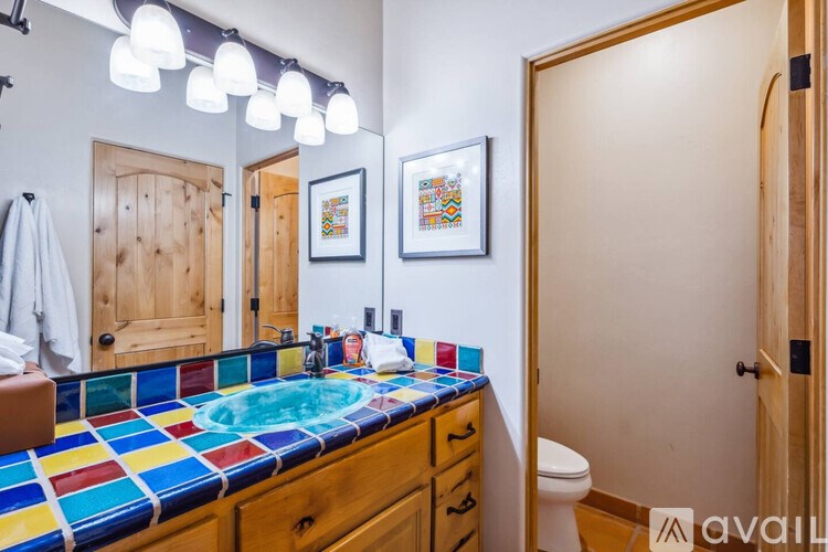 A bathroom with a blue and yellow tiled counter top.
