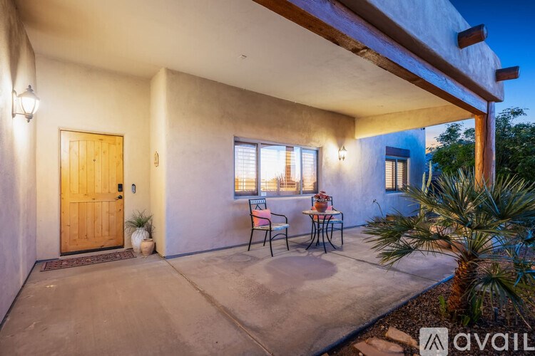 A patio with a table and chairs is set up outside a house.