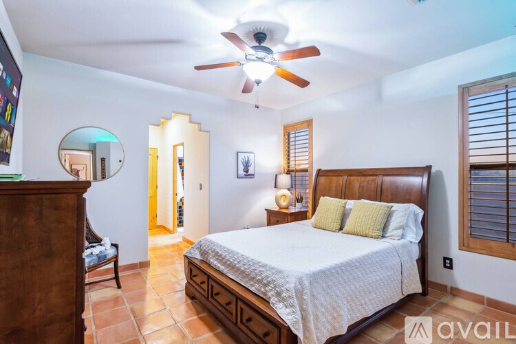 A bedroom with a bed, dresser, and mirror.