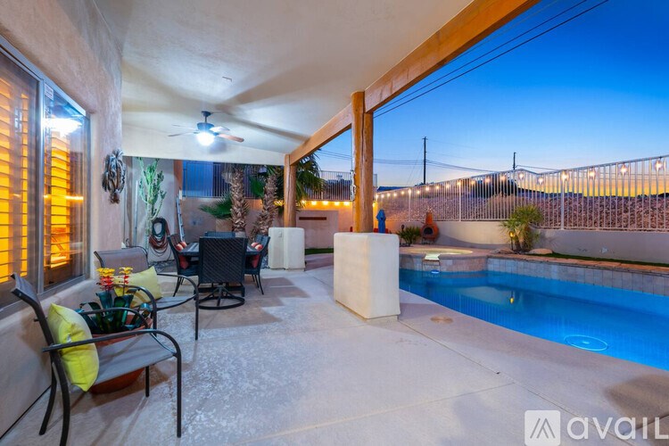 A patio with a pool and a table with chairs.
