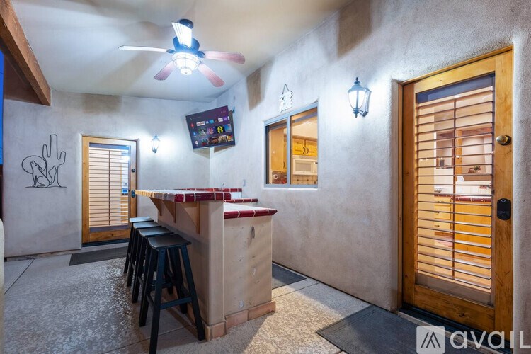 A room with a bar and a ceiling fan.