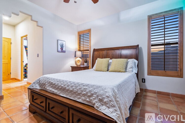A bedroom with a large bed and a ceiling fan.