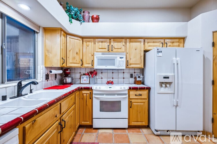 A kitchen with wooden cabinets and a white refrigerator.