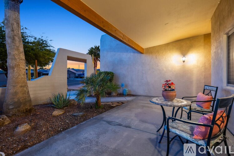 A patio with a table and chairs is set up outside a house.