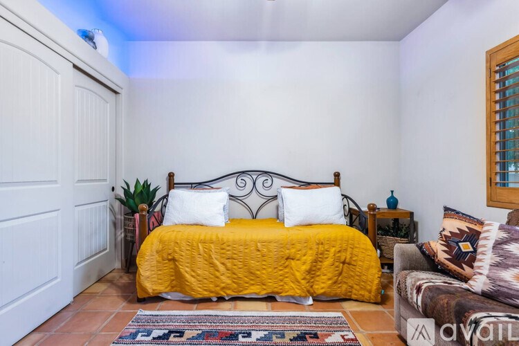 A bedroom with a yellow bedspread and a white door.