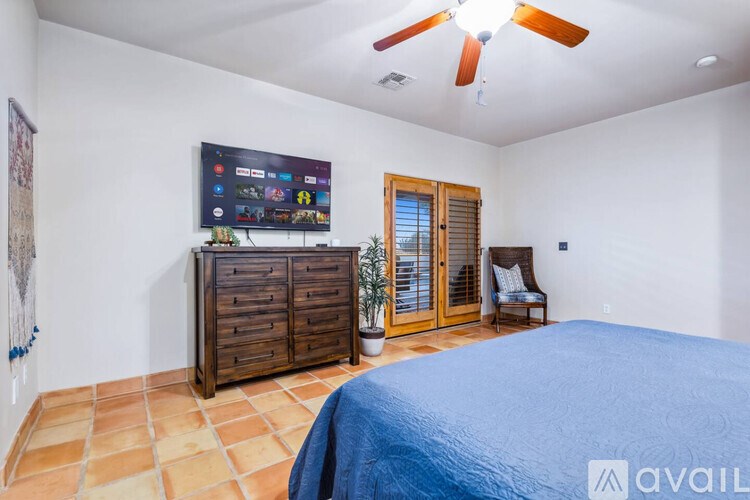 A bedroom with a large bed and a flat screen TV mounted on the wall.