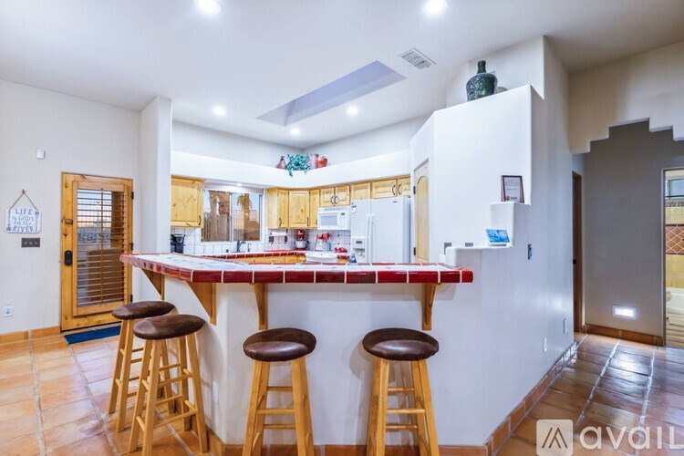 A kitchen with a bar area and stools.