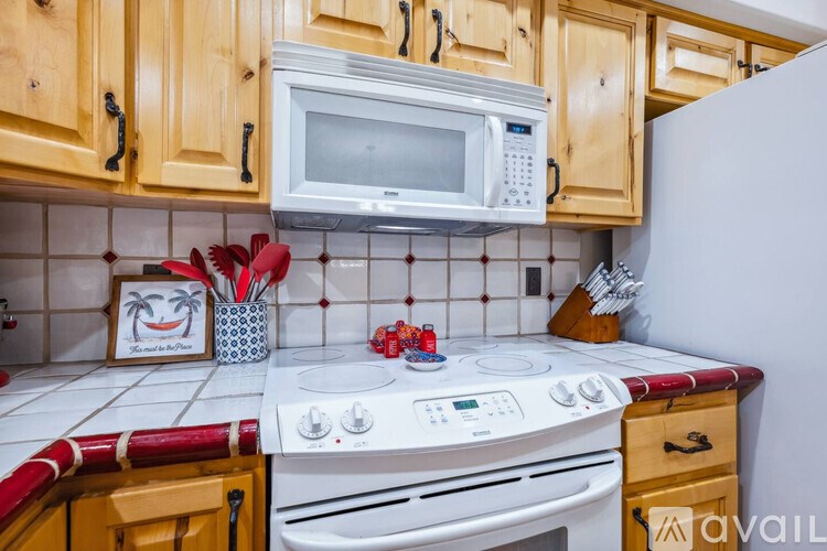 A kitchen with wooden cabinets and a white stove top oven.