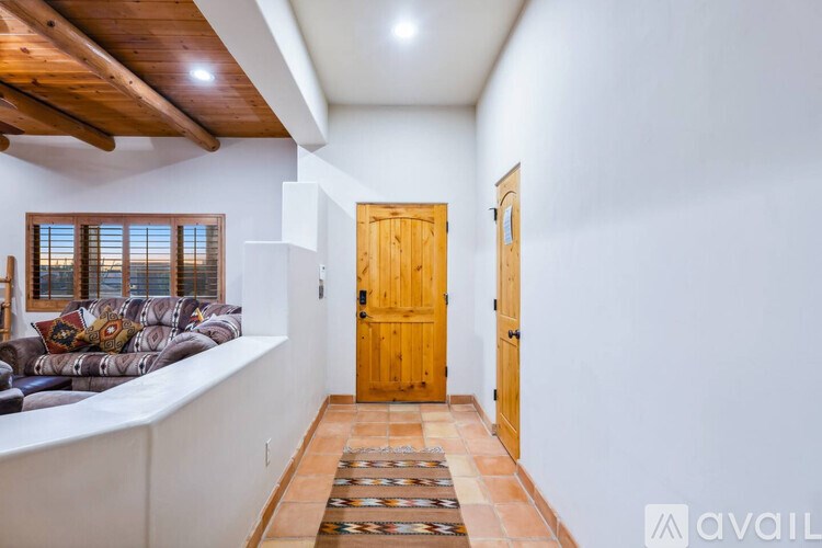 A room with a wooden door and a tiled floor.