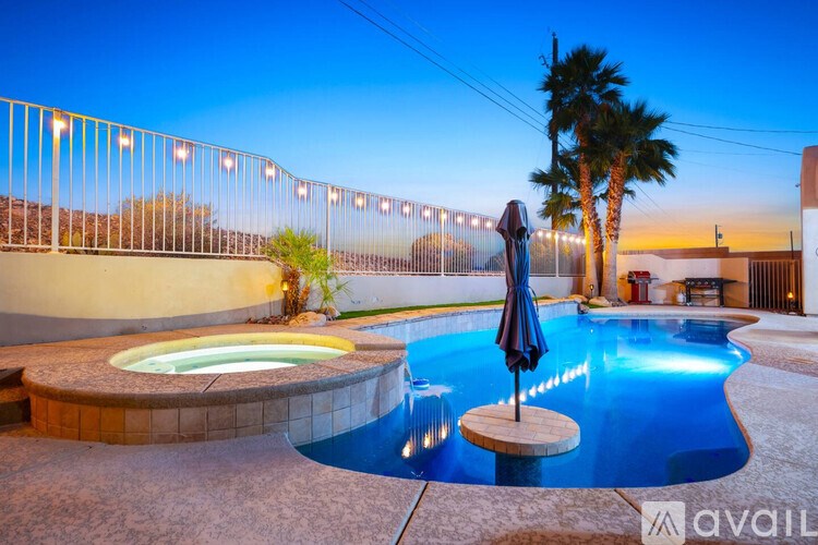 A pool with a hot tub and a palm tree.