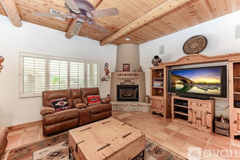A living room with a brown leather couch and a wooden coffee table.