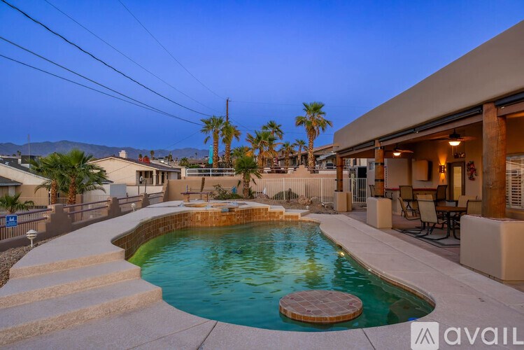 A pool with a hot tub in the middle of a backyard.