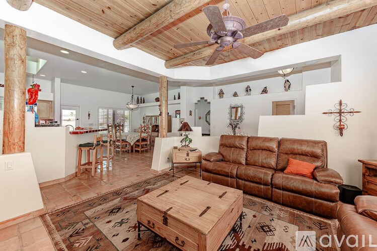A living room with a brown leather couch and a wooden coffee table.
