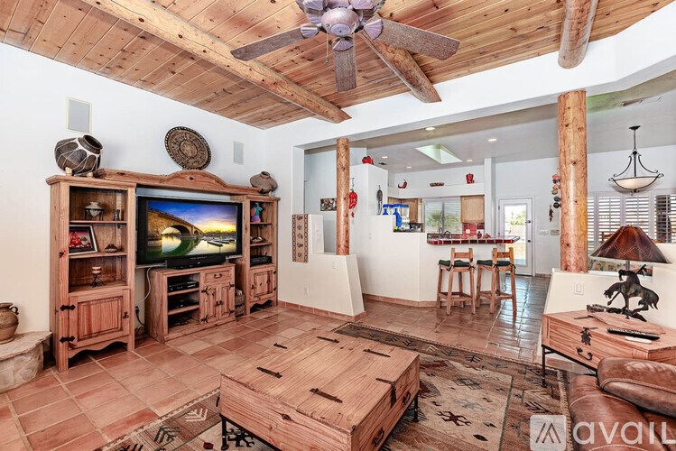 A living room with wooden furniture and a ceiling fan.