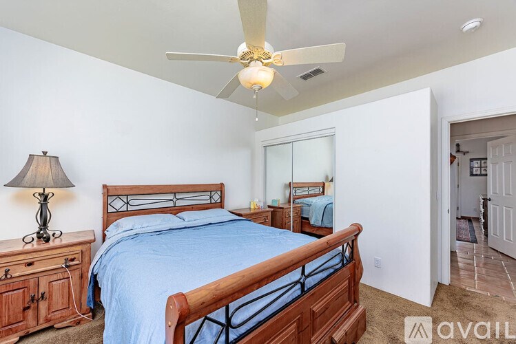 A bedroom with a bed, dresser, and mirror.