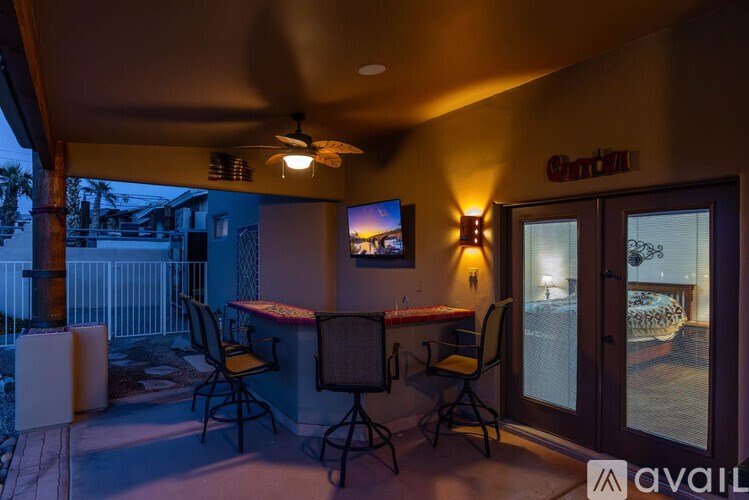 A patio area with a table, chairs, and a television.