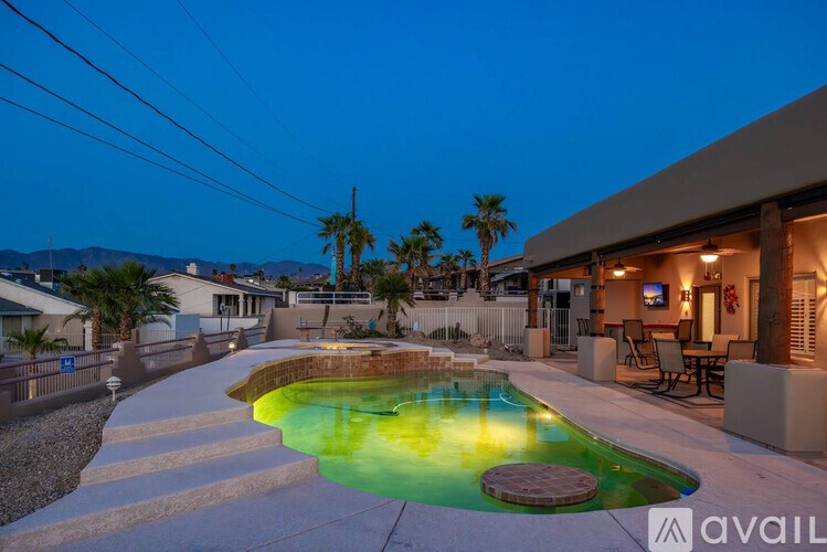 A pool with a yellowish tint in the middle of a backyard.