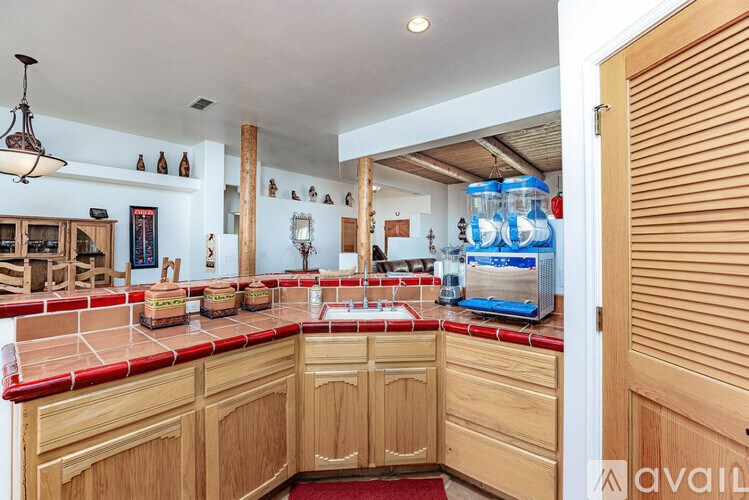 A kitchen with wooden cabinets and a red tile backsplash.