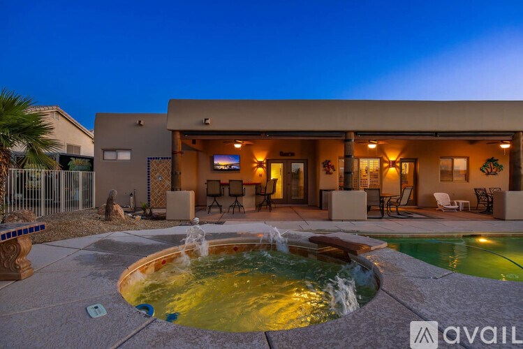 A house with a pool and a fountain in front of it.