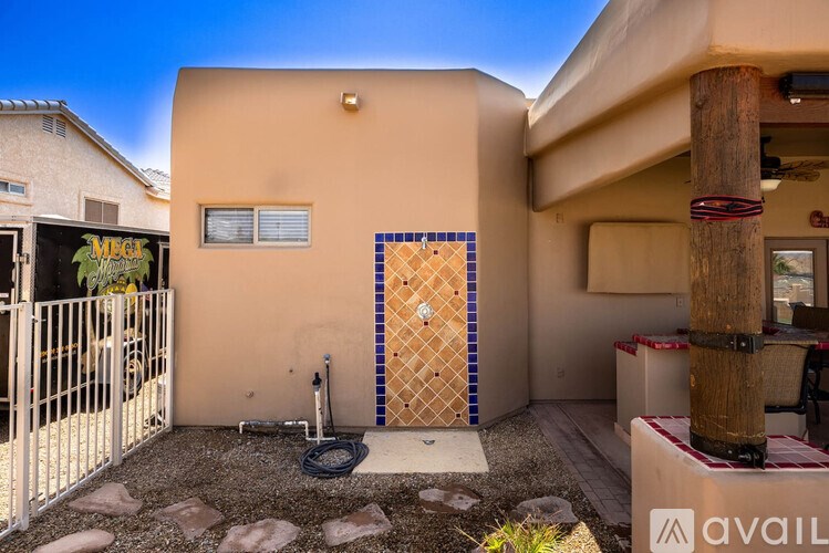 A house with a yellow door and a sign that says "MEG" on the left.