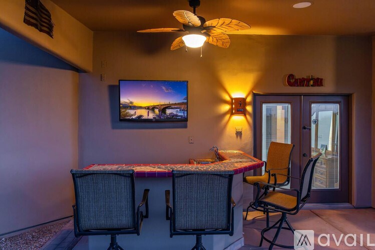 A room with a table and chairs and a television on the wall.