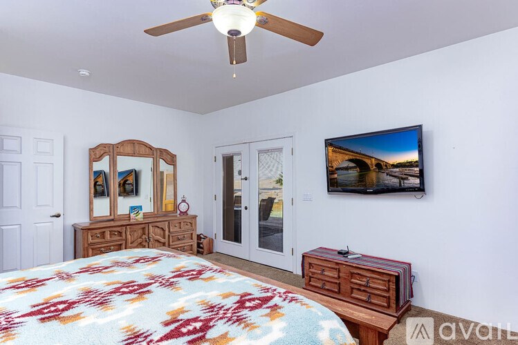 A bedroom with a bed, dresser, and television.