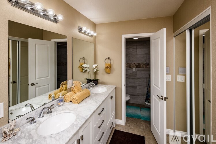 A bathroom with a marble countertop and a large mirror.