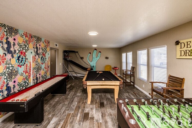 A room with a foosball table, air hockey table, and a pool table.