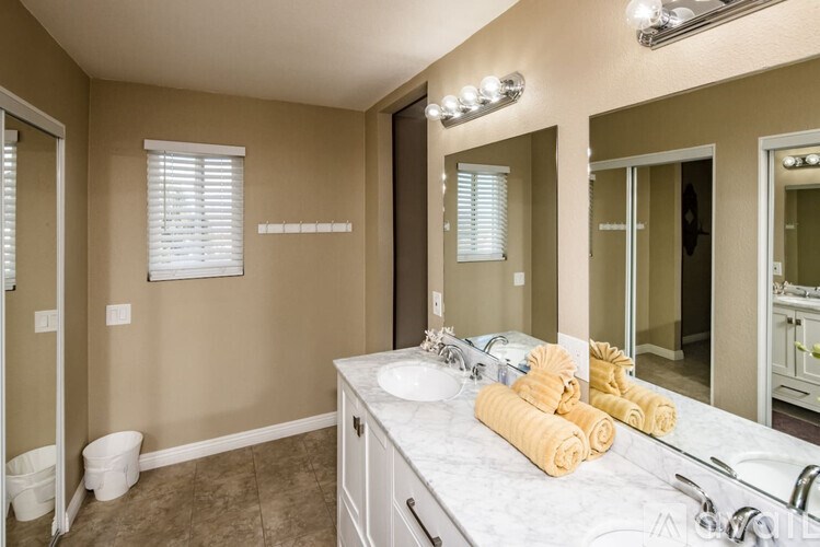 A bathroom with a white sink, brown walls, and a mirror.