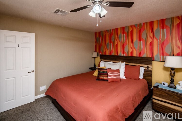 A bedroom with a bed, nightstand, and lamp.