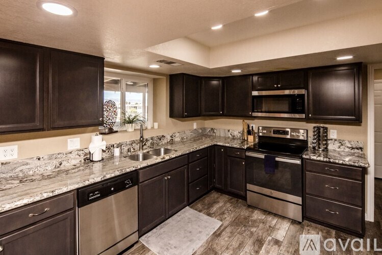 A kitchen with dark brown cabinets and stainless steel appliances.
