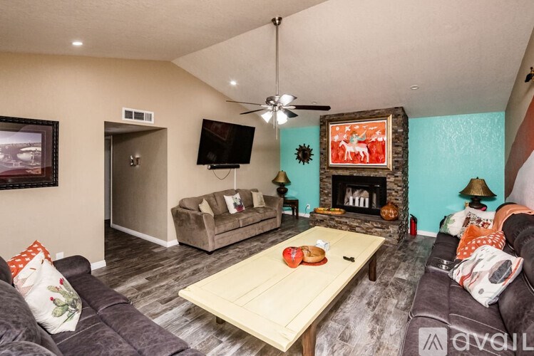 A living room with a grey couch, a wooden coffee table, and a television.