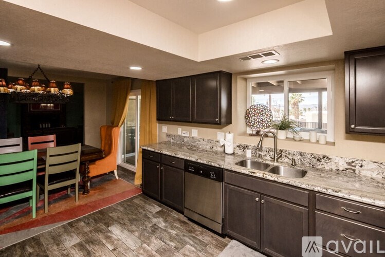A kitchen with a sink, cabinets, and a window.