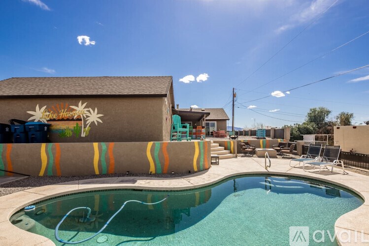A pool in front of a house with a mural of flowers on the side.