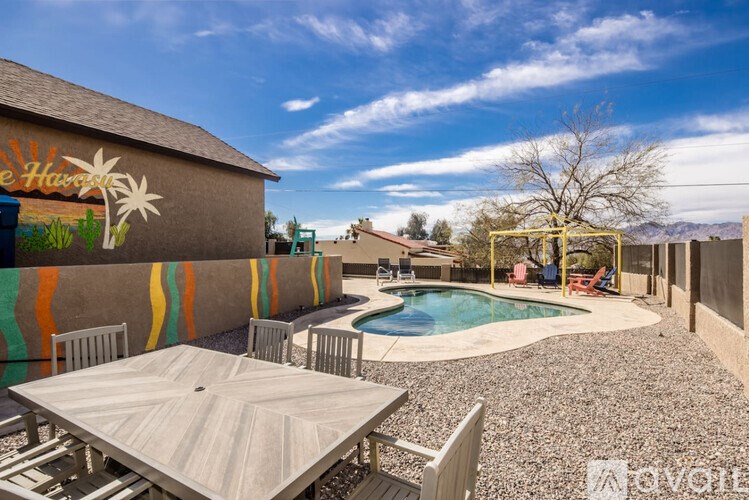 A backyard with a pool and a mural on the wall.